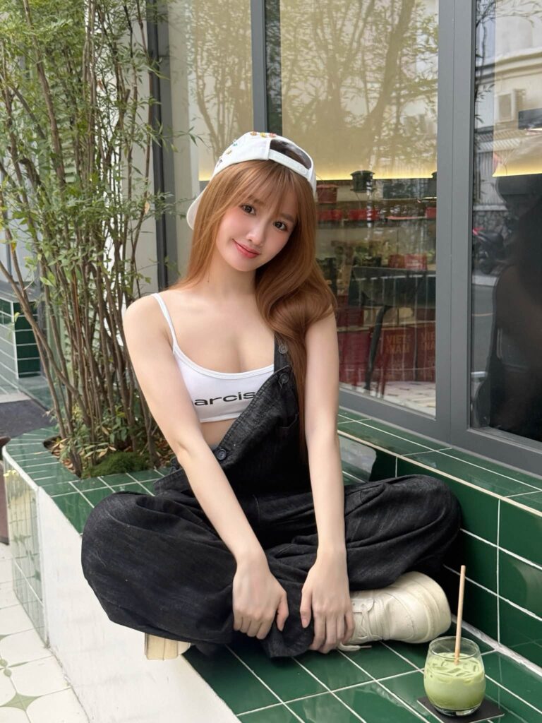 Khánh Huyền nằm tạo dáng trên nắp chiếc xe màu trắng