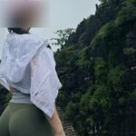 Cô gái mặc trang phục thể thao đứng giữa khung cảnh núi đá