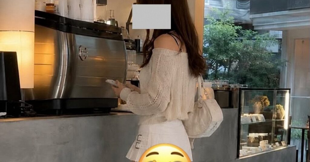 Cô gái tạo dáng tại khu vực quầy gọi đồ của một quán cà phê
