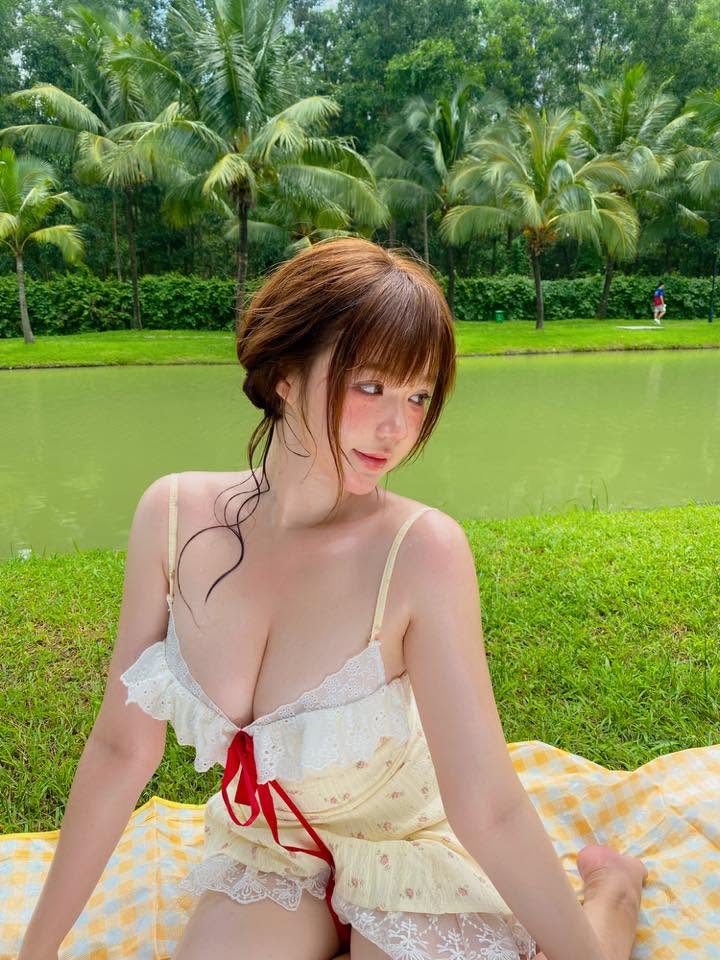 Kami tạo dáng tự nhiên giữa bảng hiệu và khay đồ ăn đường phố