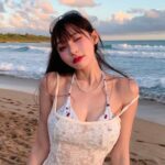 Mizuki đứng bên bờ biển dưới ánh hoàng hôn