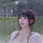Cô gái ngồi trên ghế gỗ dưới tán cây tại Hồ Gươm