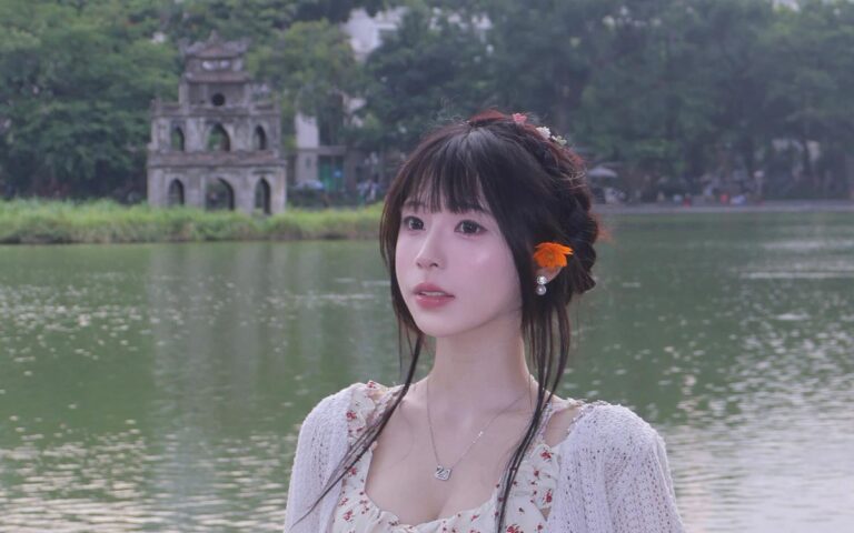 Cô gái ngồi trên ghế gỗ dưới tán cây tại Hồ Gươm