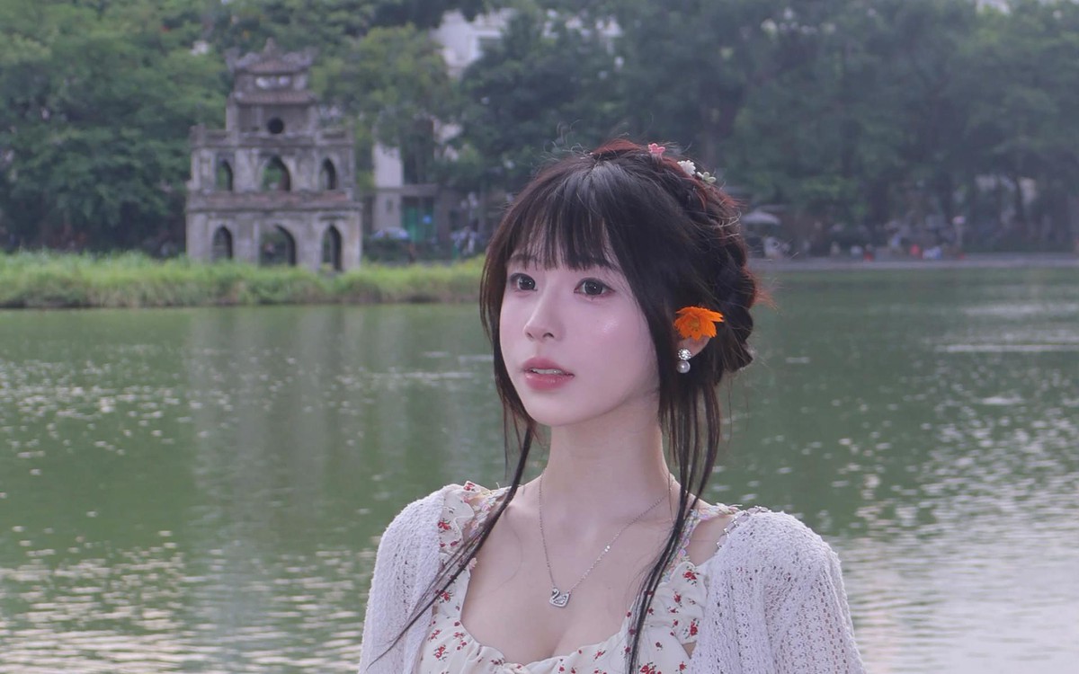 Cô gái ngồi trên ghế gỗ dưới tán cây tại Hồ Gươm