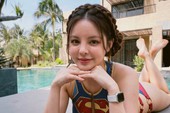Yuna Vũ chỉnh kính khi tạo dáng trước biển