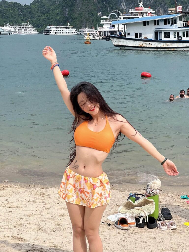 Bộ bikini màu cam nổi bật giữa không gian biển và ánh nắng
