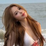 Hà Môi tạo dáng trong trang phục đi biển màu trắng trước khung cảnh biển