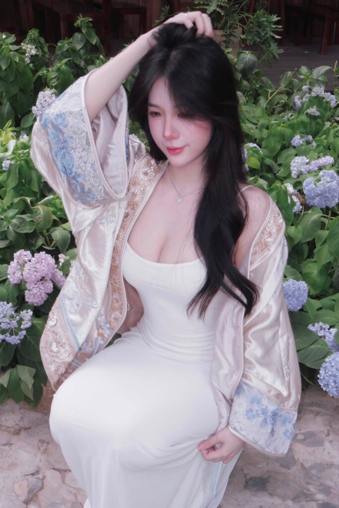 Tú Uyên đứng với tà đầm đỏ buông tự nhiên bên cạnh
