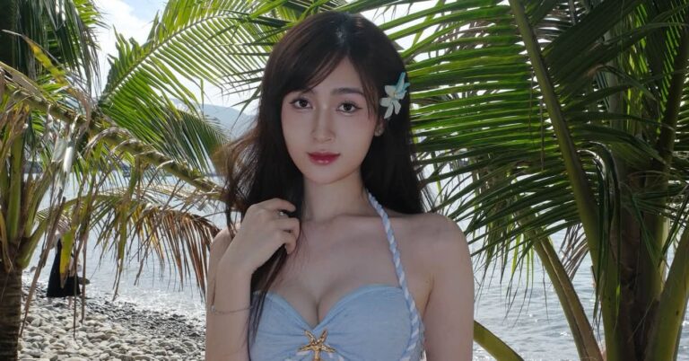 Ngọc Thủy diện bikini xanh pastel giữa khung cảnh biển và hàng dừa