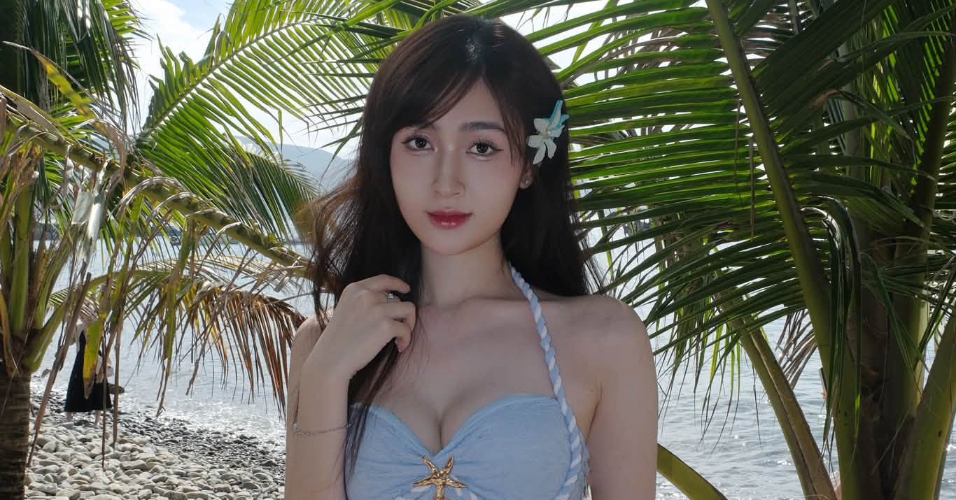 Ngọc Thủy diện bikini xanh pastel giữa khung cảnh biển và hàng dừa