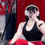 Nữ gymer mặc áo ba lỗ đen và quần tập đỏ trong phòng gym
