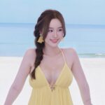 Hàn Trang diện váy vàng tạo dáng bên bãi biển xanh