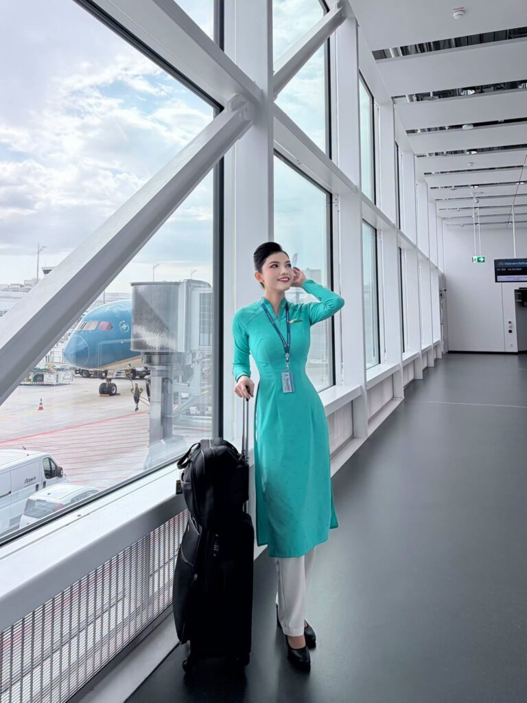 Trang Aiko cầm máy ảnh khi đứng trên bãi biển