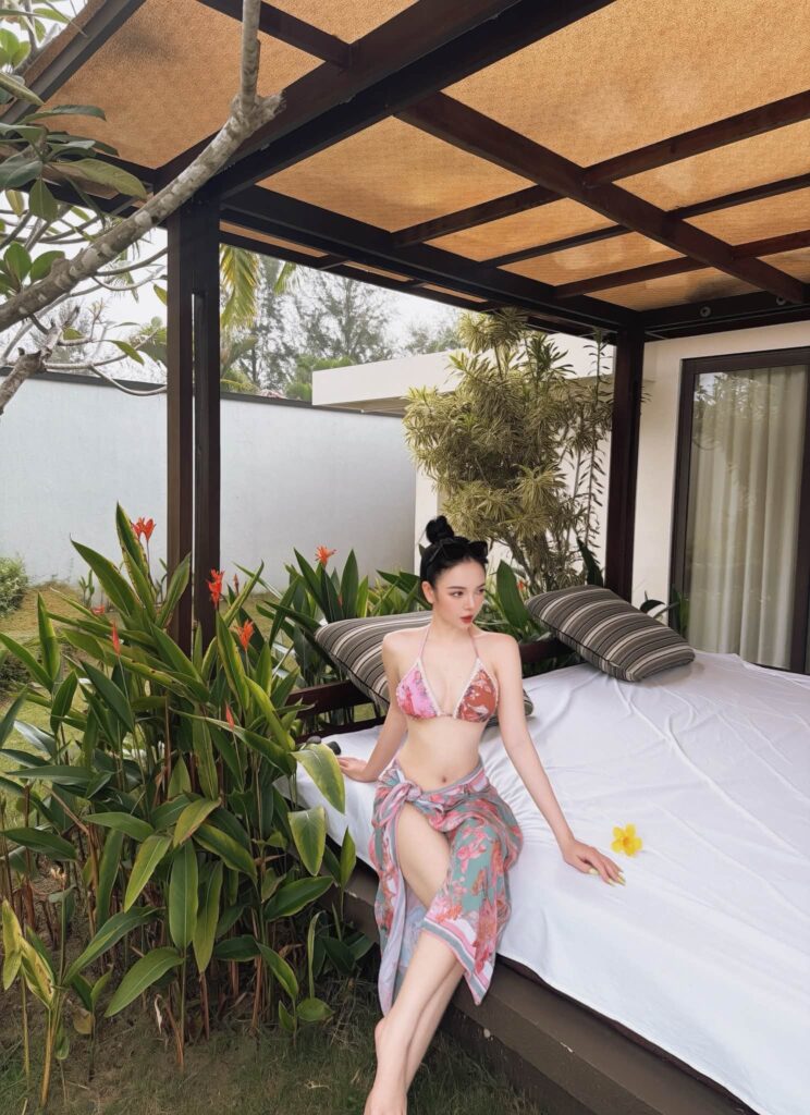 Hot girl U40 tạo dáng thư giãn bên khu vực nghỉ ngoài trời