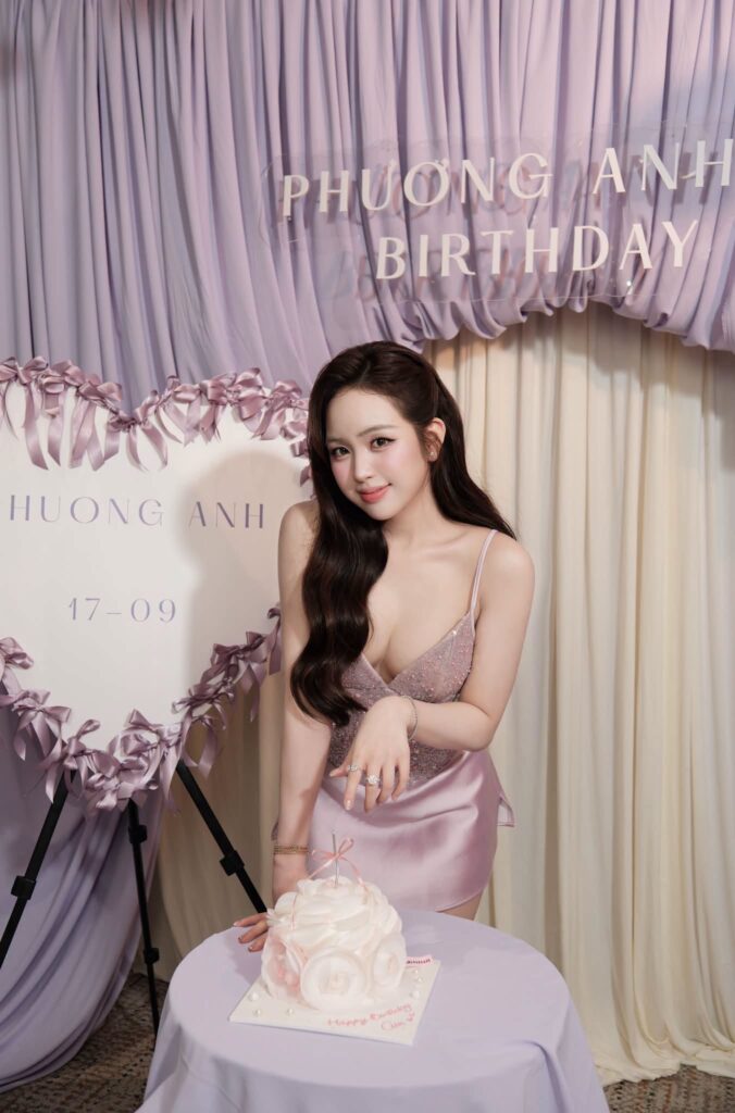 Lê Phương Anh mỉm cười khi ngồi cạnh bàn tiệc sinh nhật