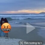 Hai cô gái mặc trang phục đi biển chụp ảnh tại bãi biển Mỹ Khê