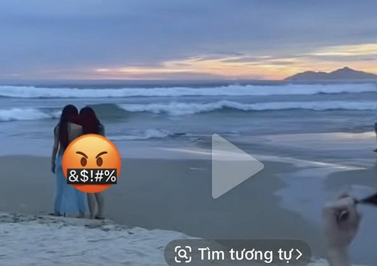 Hai cô gái mặc trang phục đi biển chụp ảnh tại bãi biển Mỹ Khê