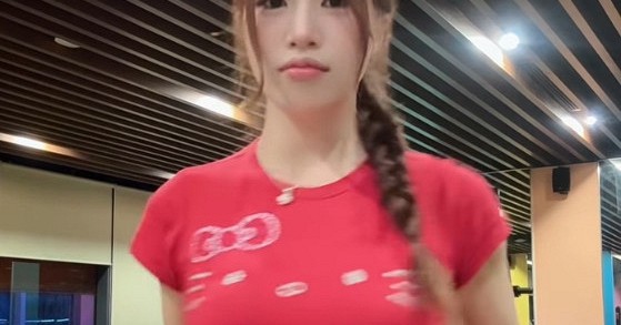 Anh Thơ đứng trong phòng tập gym với trang phục thể thao màu đỏ