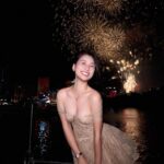 Trần Thu Huyền đứng trước màn pháo hoa rực sáng trên bầu trời đêm