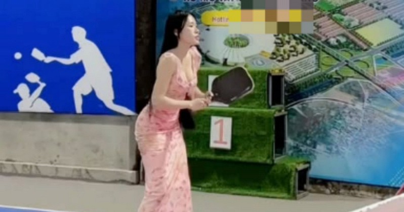 Nữ nhân viên kinh doanh bất động sản diện váy hồng cầm vợt Pickleball