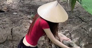 Cô gái trẻ đứng giữa khu vực có cây cối và mặt nước