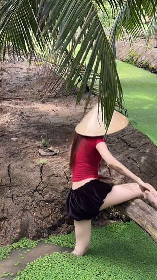 Khoảnh khắc cô gái cúi xuống tìm ốc ở vùng nước nông