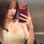 Lê Lý Lan Hương selfie trước gương trong thang máy với váy vàng ánh kim