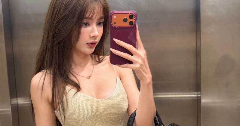 Lê Lý Lan Hương selfie trước gương trong thang máy với váy vàng ánh kim